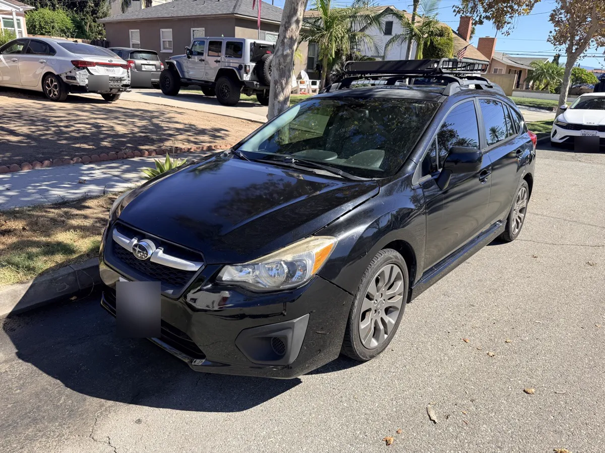 Black Subaru Impreza hatchback, front three-quarter view