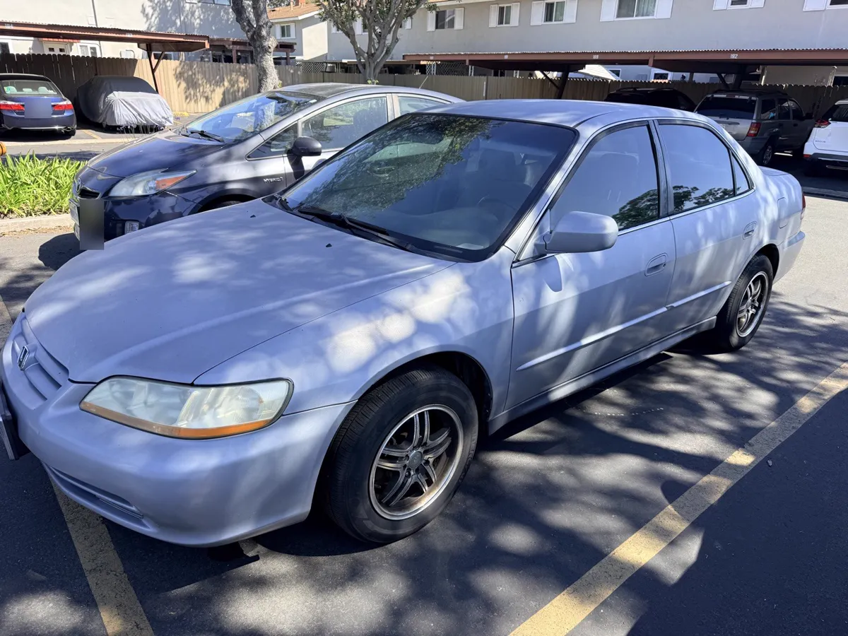 Light blue Honda Accord sedan parked in a lot, front three-quarter view