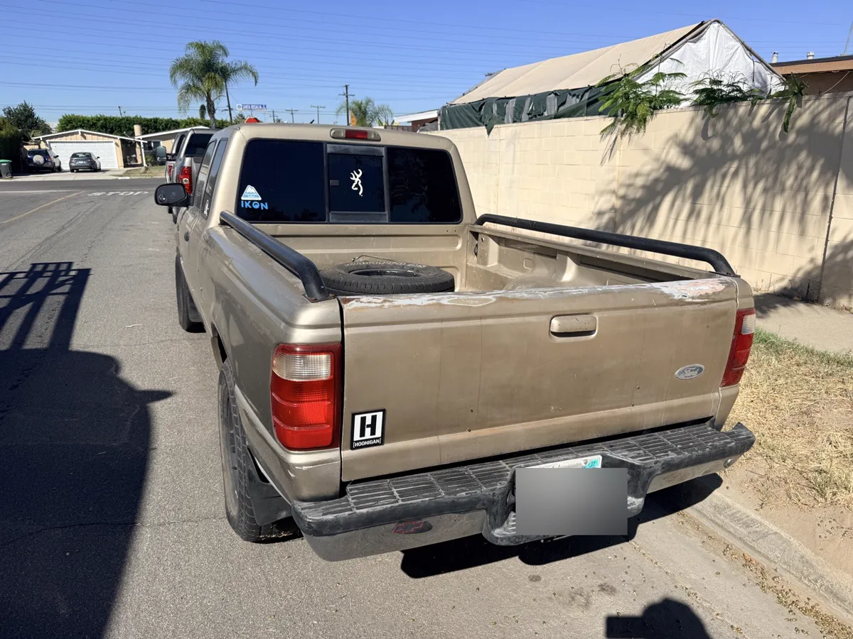 Tan Ford Ranger pickup, rear three-quarter view
