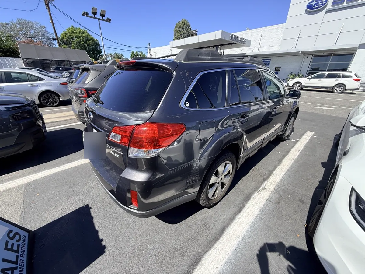Dark gray Subaru Outback, rear three-quarter view