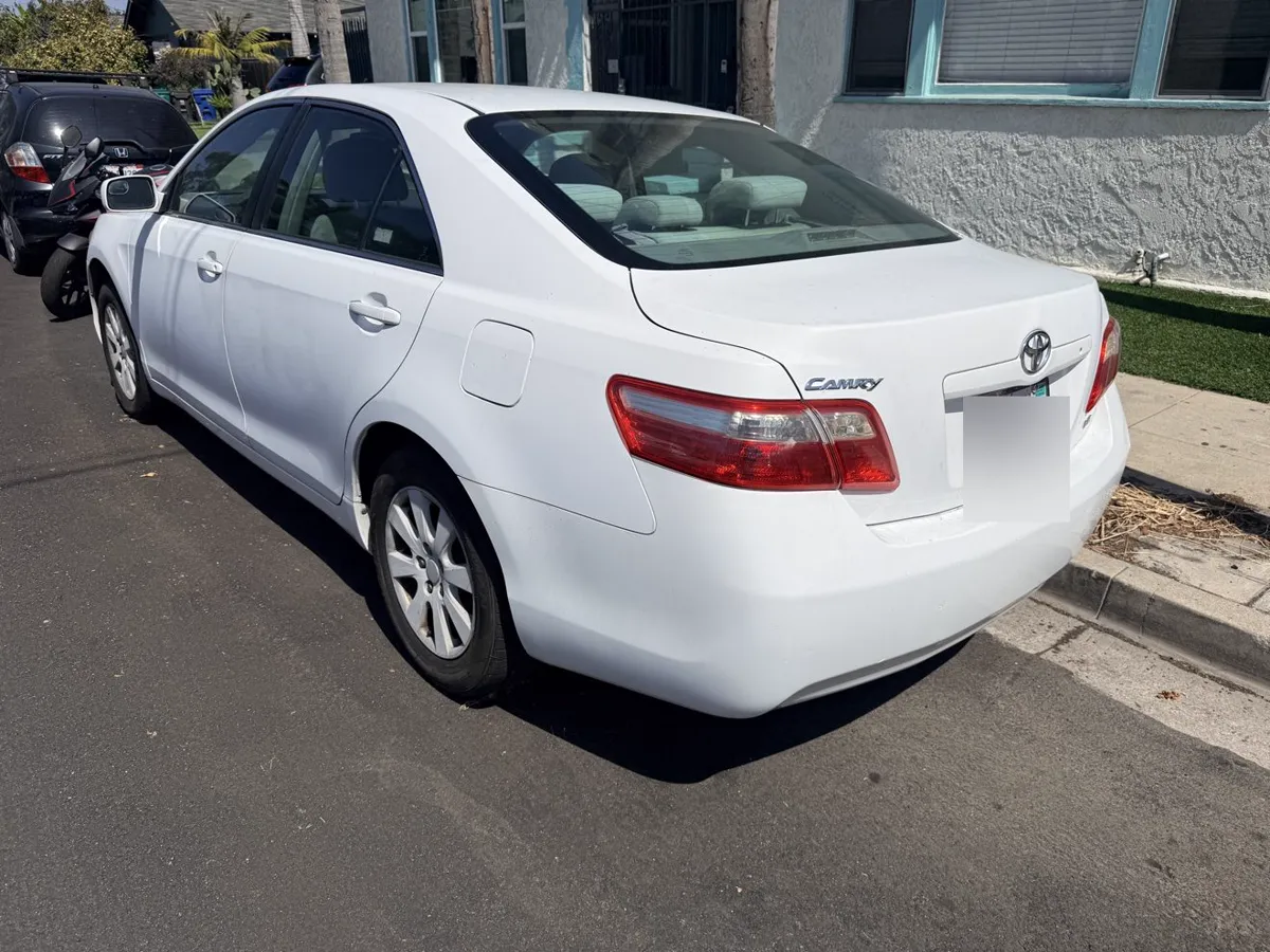 White Toyota Camry, rear three-quarter view