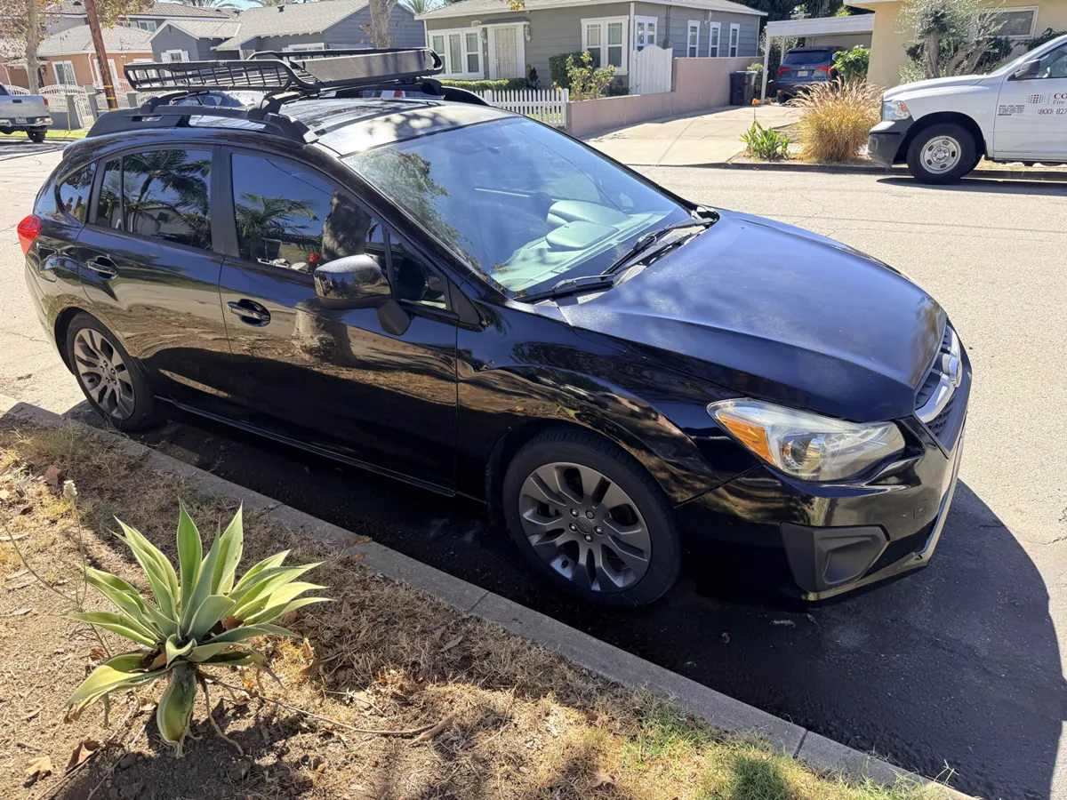 Black Subaru Impreza hatchback, side view
